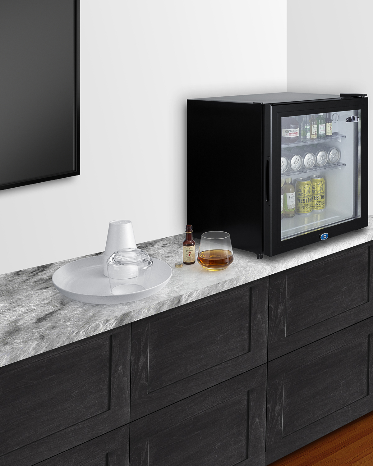 Compact minibar with reversible glass door, front lock, and glossy black cabinet